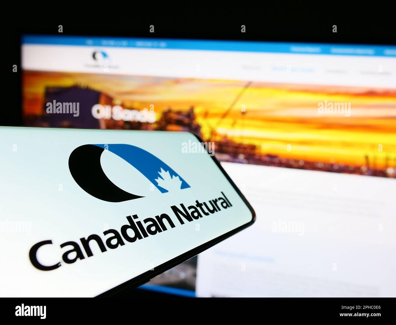 Téléphone cellulaire avec logo de la société Ressources naturelles canadiennes limitée à l'écran devant le site Web des affaires. Effectuez la mise au point au centre-droit de l'écran du téléphone. Banque D'Images