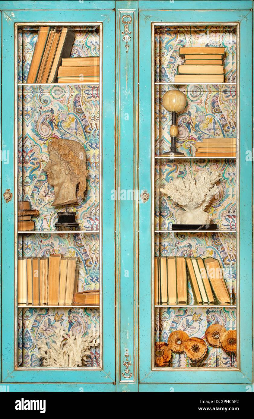 Façade d'une bibliothèque d'époque avec une surface verte en rade, des portes en verre transparent et des livres anciens sur les étagères. Banque D'Images