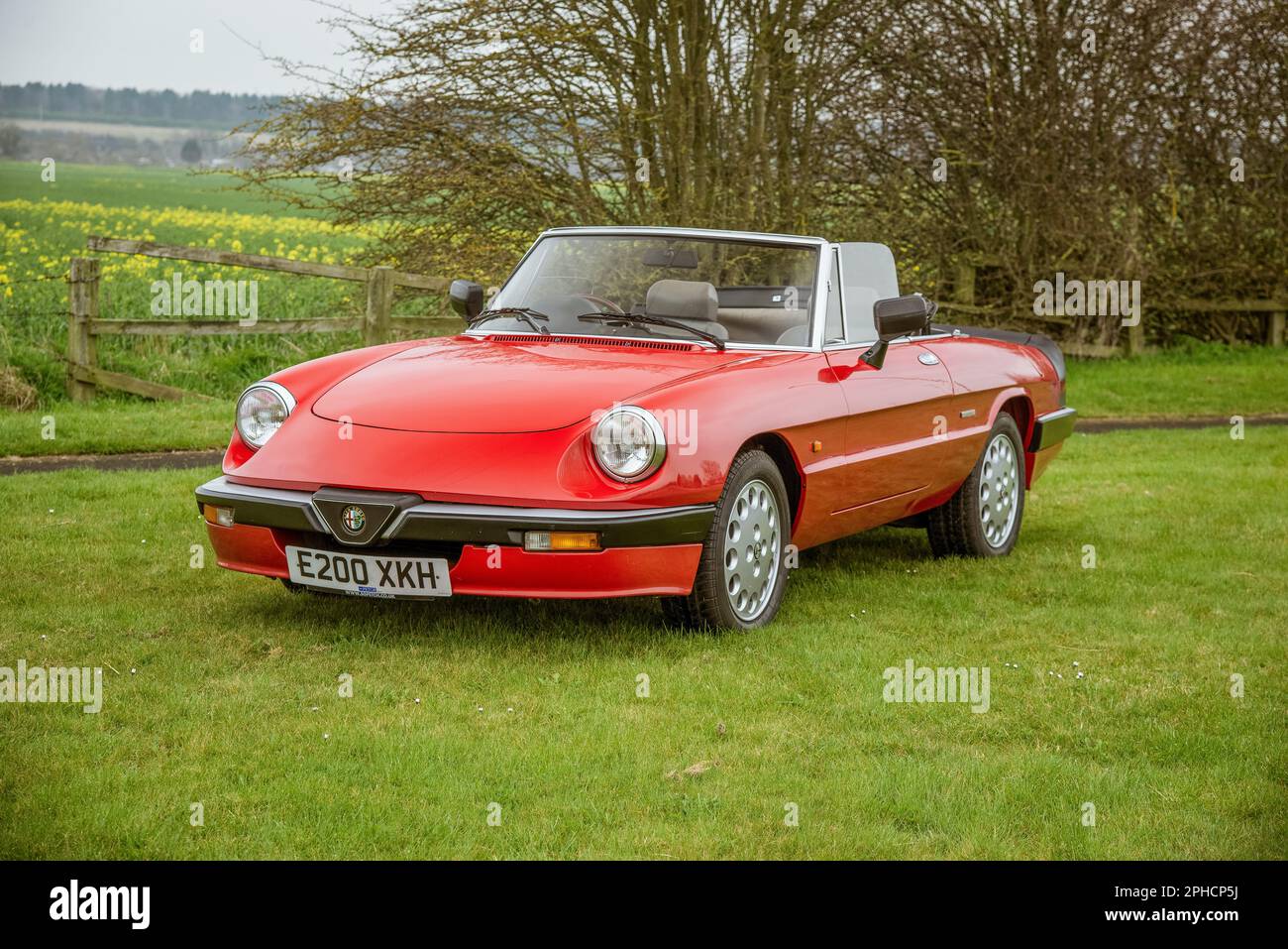 Red Alfa Romeo Spider Series 3 (série 115) garée dans un pré avec le toit en bas Banque D'Images