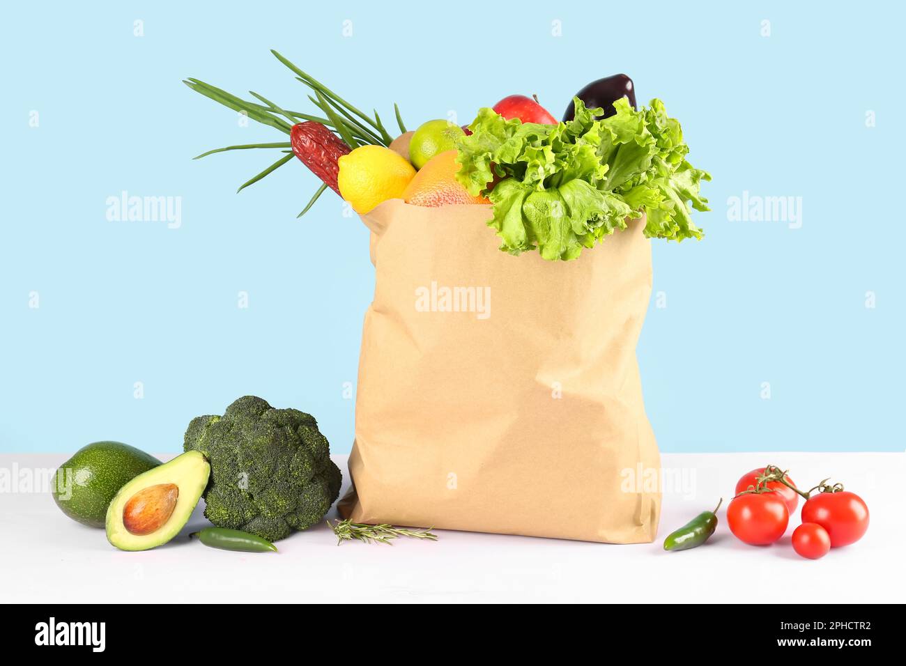 Sac en papier avec légumes, fruits et saucisses sur la table Photo Stock -  Alamy