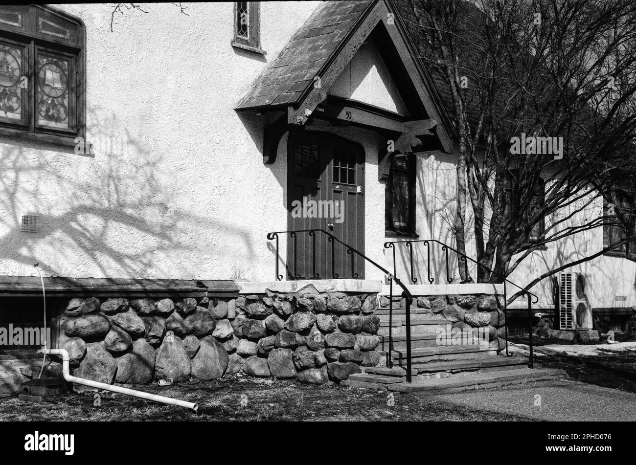 Une église classique en stuc blanc avec style vintage en besoin de réparations à Stoneham, Massachusetts. L'image a été capturée en noir analogique et Banque D'Images