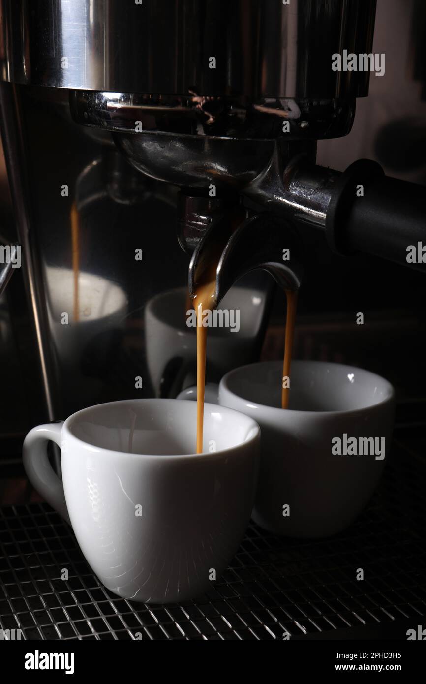 Faire des espressos frais et aromatiques en utilisant une machine à café professionnelle dans un café, en gros plan Banque D'Images