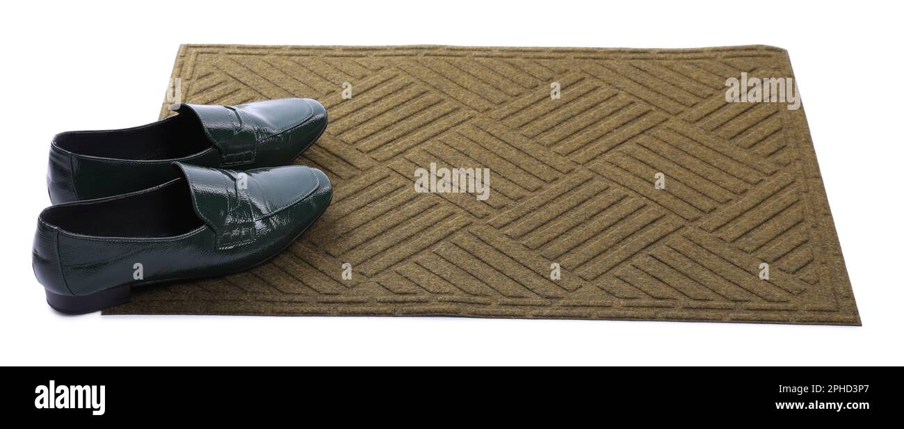 Nouveau tapis de porte propre avec des chaussures sur fond blanc Banque D'Images
