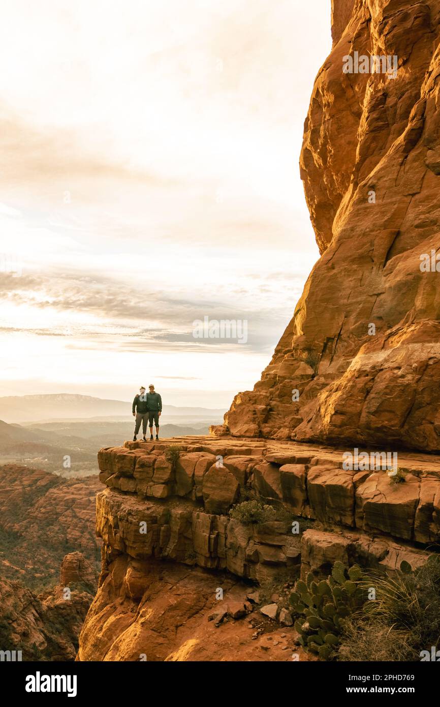 Les jeunes couples sont côte à côte au-dessus de Cathedral Rock à Sedona pose pour la photo verticale. Banque D'Images