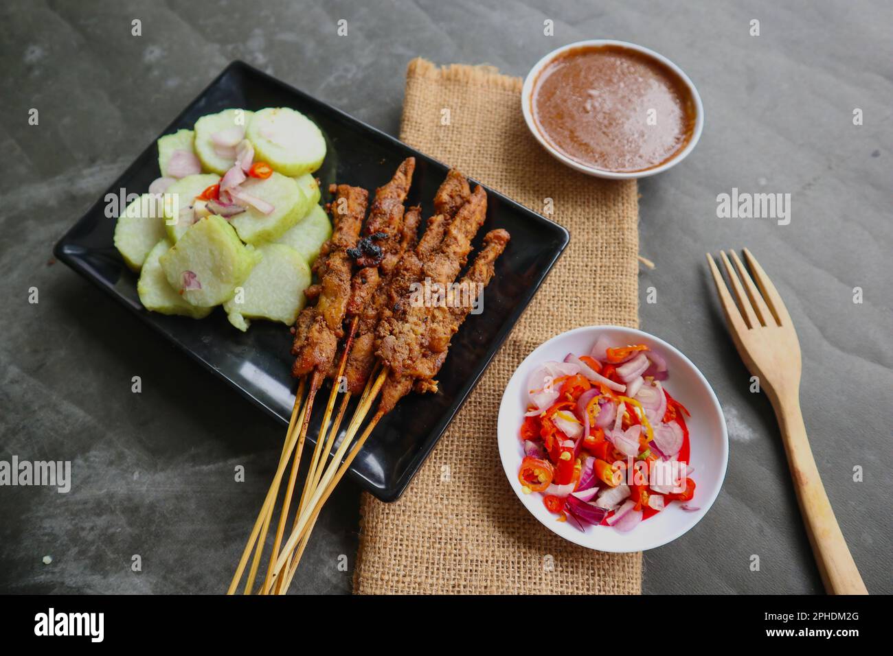 satay de poulet ou satay de poulet servi avec du lontong, du gâteau de riz et de la sauce aux arachides. Banque D'Images