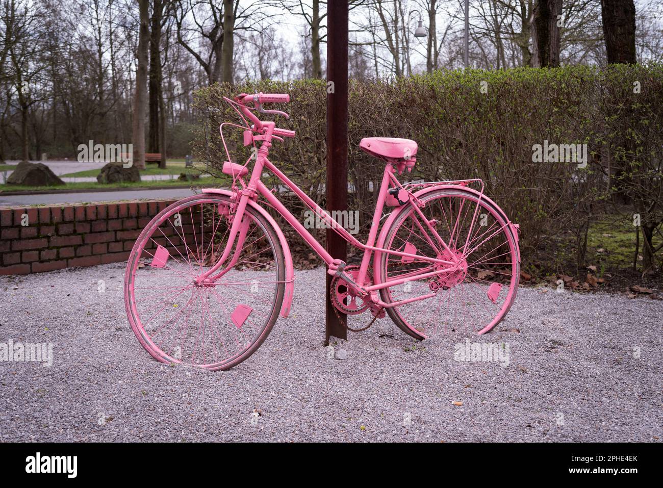 femme rose vélo contre un poteau Banque D'Images