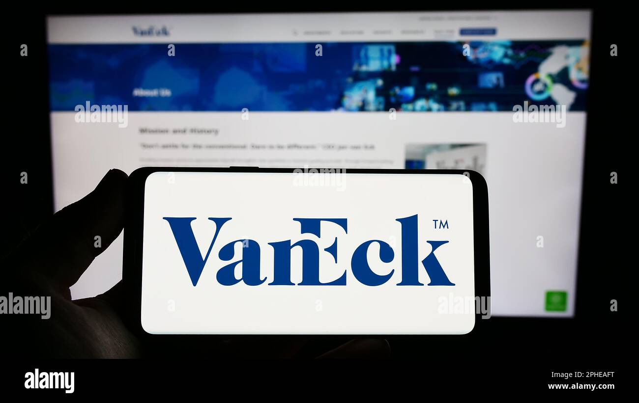 Personne tenant un smartphone avec le logo de la société américaine de gestion d'investissement VanEck sur l'écran devant le site Web. Mise au point sur l'affichage du téléphone. Banque D'Images