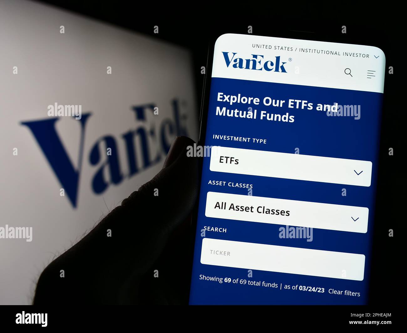 Personne tenant le téléphone portable avec la page web de la société américaine de gestion d'investissement VanEck sur l'écran devant le logo. Concentrez-vous sur le centre de l'écran du téléphone. Banque D'Images