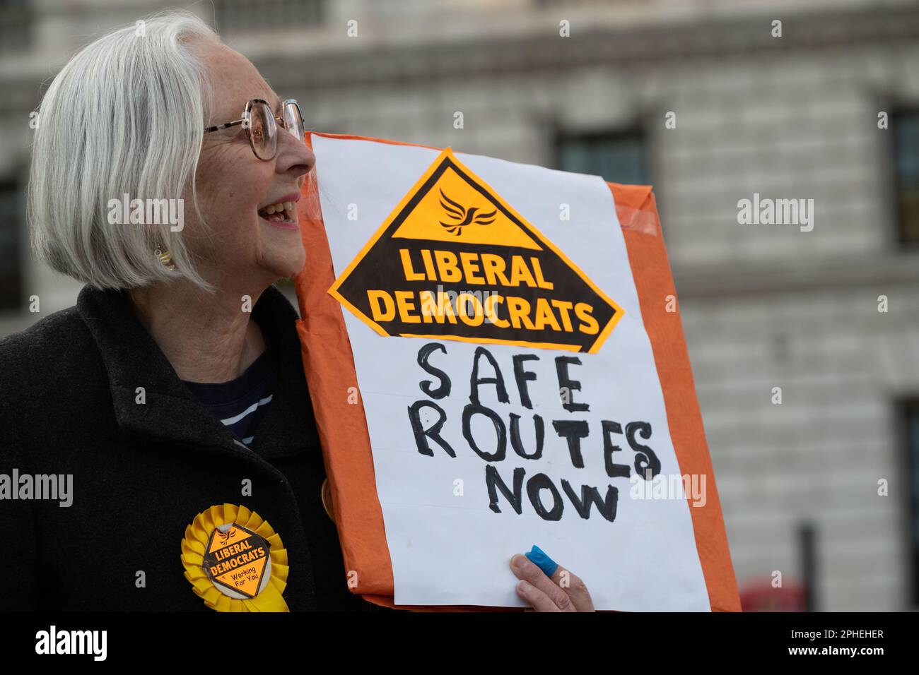 Un militant libéral démocrate qui réclame « Safe routes Now » lors d'un rassemblement contre le projet de loi controversé sur les migrations illégales devant le palais de Westminster Banque D'Images