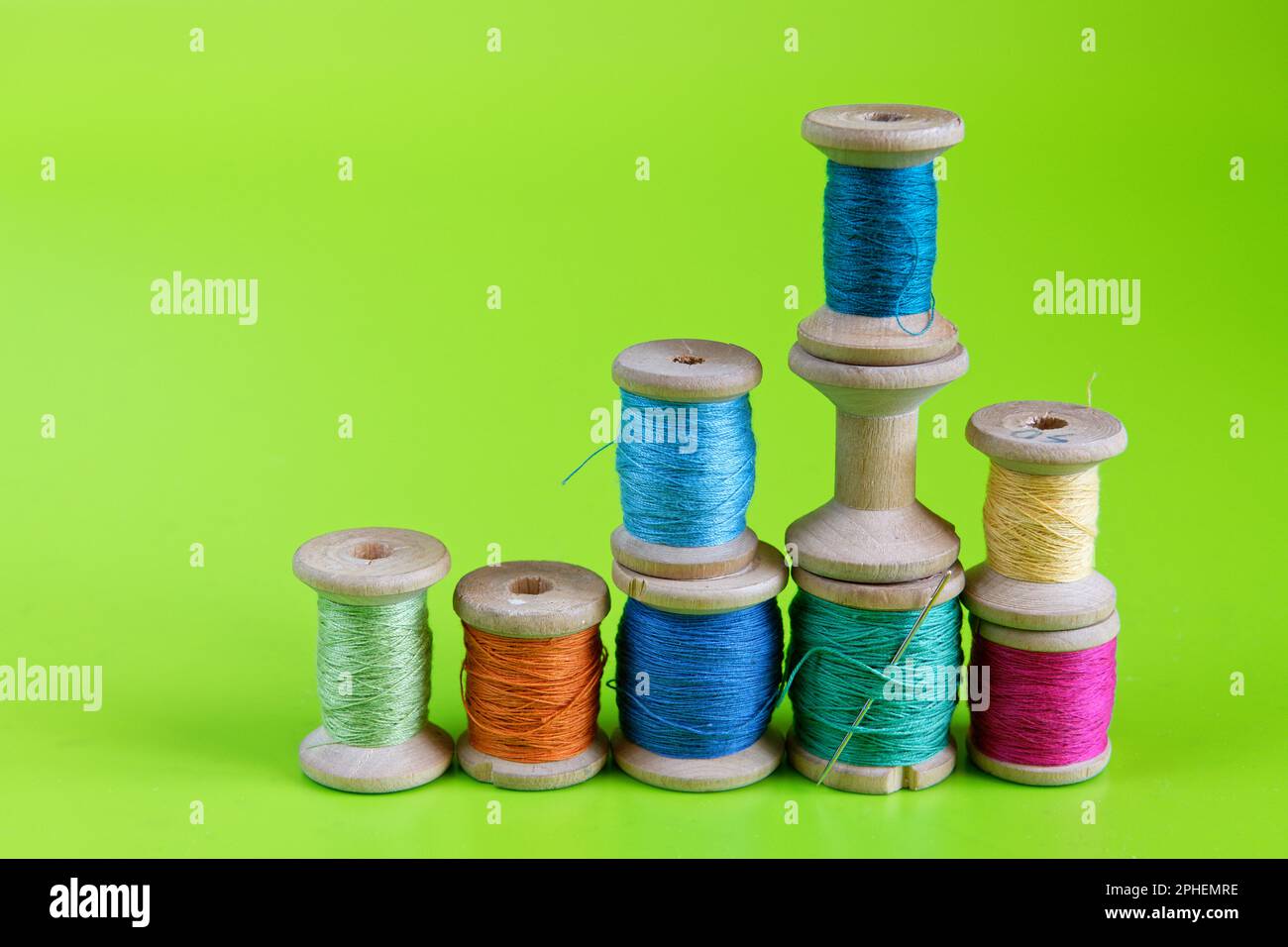 Vieux rouleaux de fil en bois sur fond vert Banque D'Images