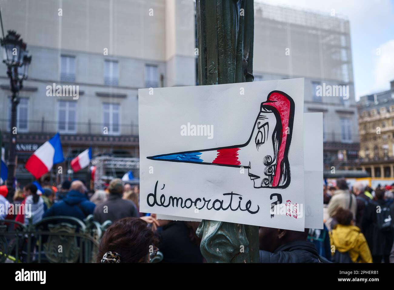 Paris, France. 25 mars 2023. Affiche disant « démocratie ? » En français, dans une protestation contre la réforme des retraites en dehors du Palais-Royal. Banque D'Images