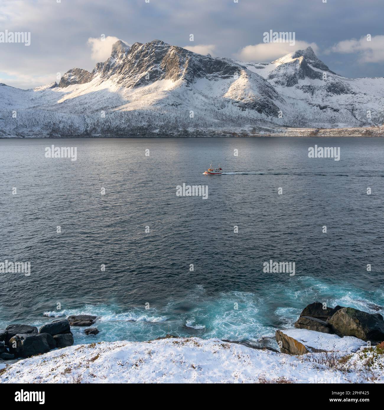 Fischer am Morgen, Schiff im Øyfjorden, mit den schneebematten Bergen von Senja, genannt Segla, Kongan und Skuran im hintergrund. Norwegen Banque D'Images