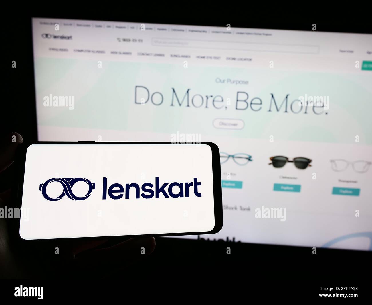 Personne tenant un smartphone avec le logo de la compagnie indienne de lunettes Lenskart sur l'écran devant le site Web. Mise au point sur l'affichage du téléphone. Banque D'Images