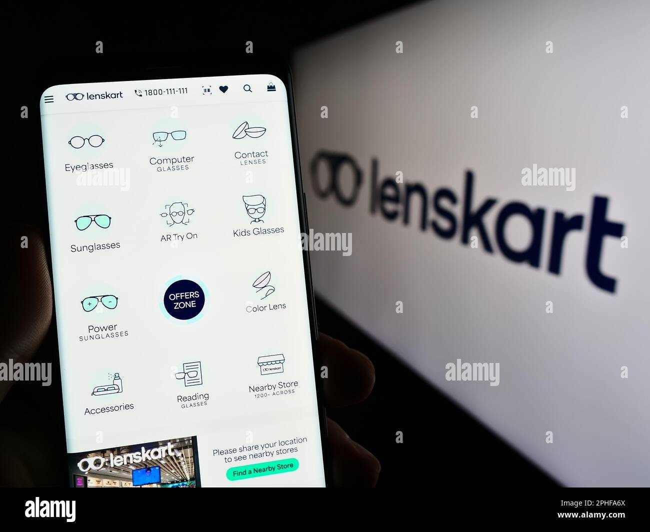 Personne tenant un téléphone mobile avec le site Web de la compagnie indienne de lunettes Lenskart sur l'écran devant le logo. Concentrez-vous sur le centre de l'écran du téléphone. Banque D'Images