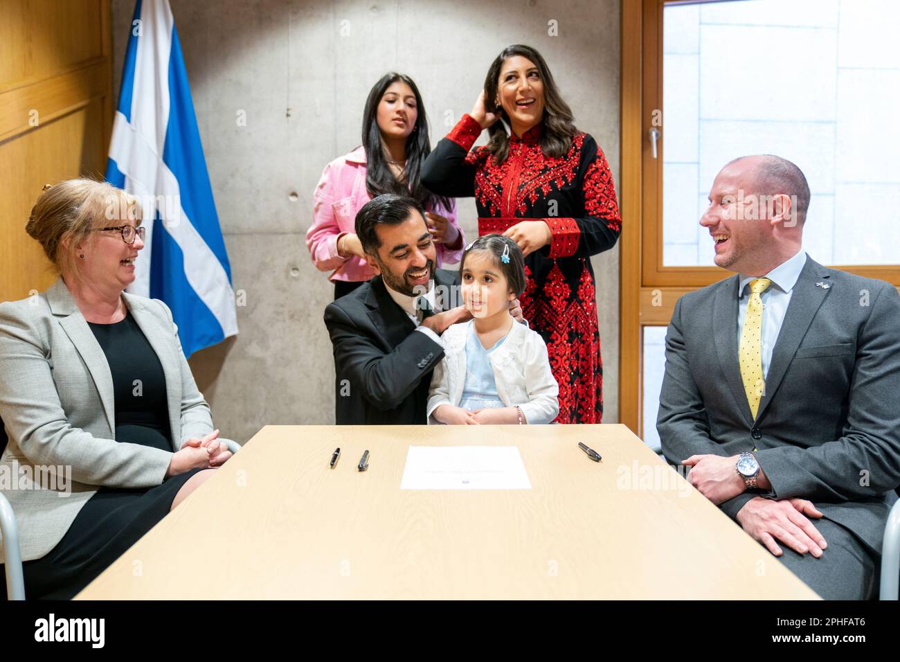 Humza Yousaf, le nouveau chef du Parti national écossais, signe le formulaire de nomination pour devenir Premier ministre écossais, sous la surveillance de son épouse Nadia El-Nakla (en arrière à droite), de sa fille Amal, 3 ans, de sa belle-fille Maya (en arrière à gauche), de l'auteur de la proposition Shona Robison (à gauche) et du second Neil Gray, au Parlement écossais à Édimbourg. Le MSPS votera aujourd'hui la nomination de M. Yousaf au poste de sixième Premier ministre écossais. Date de la photo: Mardi 28 mars 2023. Banque D'Images