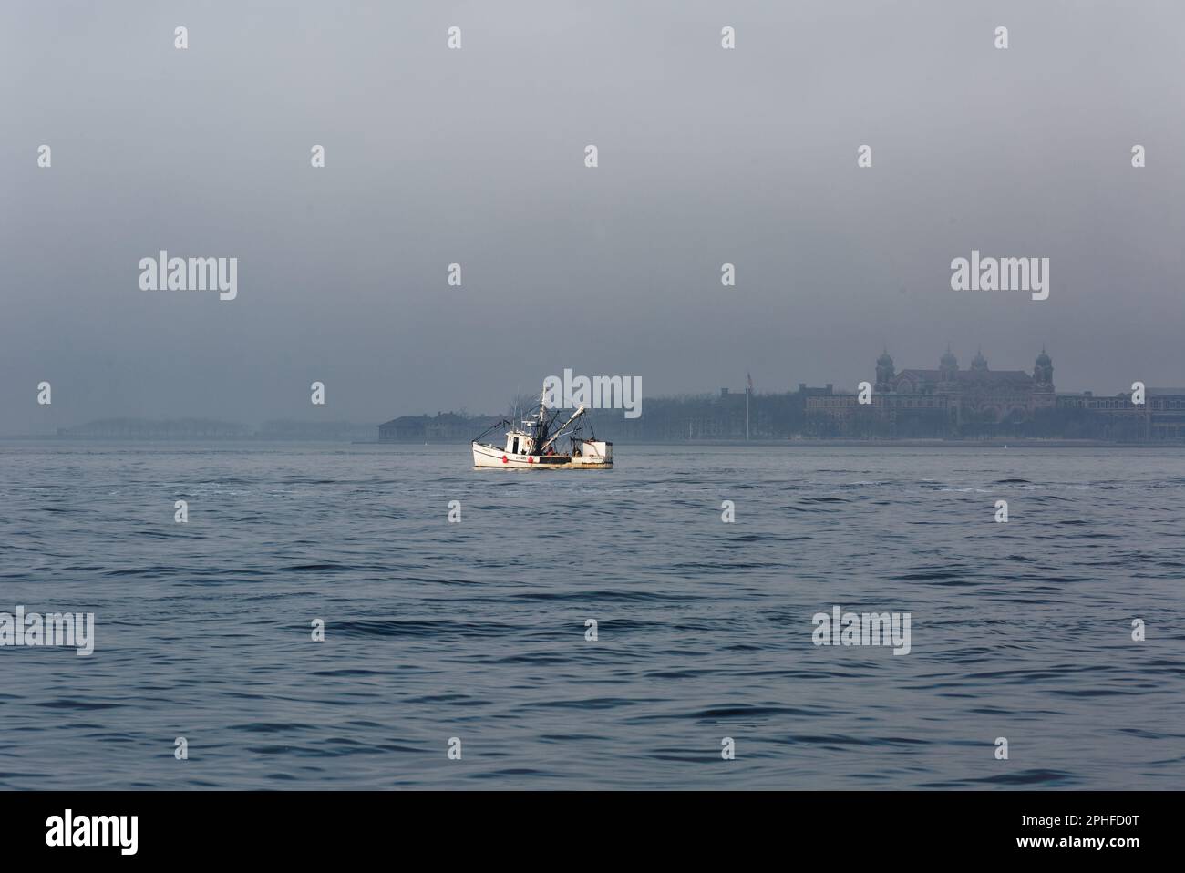 Un chalutier de pêche, Virginia Sue, dans les eaux calmes du port de New York / Upper Bay, un matin brumeux de février. Banque D'Images