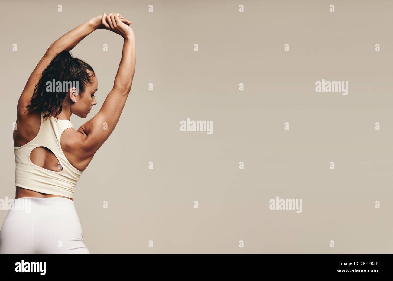 Jeune femme sportive qui s'entraîne dans un studio avec des exercices d'étirement de tonification musculaire. Jeune femme athlétique cherchant à améliorer la flexibilité et l'équilibre thr Banque D'Images