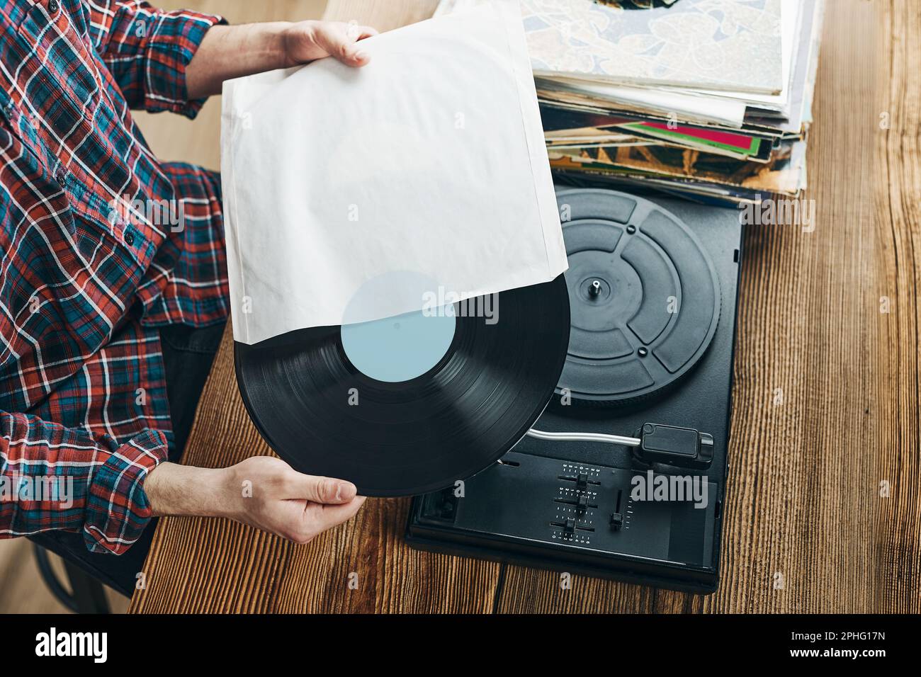 Homme écoutant de la musique à partir d'un disque vinyle. Lecture de musique à partir d'un disque analogique sur le lecteur de platine. Écouter de la musique de l'ancienne collection. Détente à la maison. Réf Banque D'Images