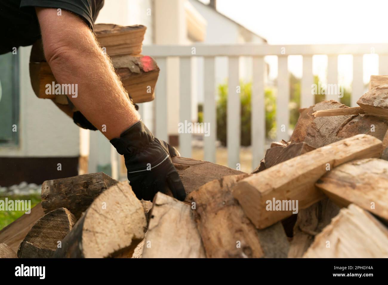 Dans le jardin se trouve une pile de bois de hêtre qui ont été livrés. Un homme se plie et soulève une armue de grumes pour le prendre à la tablette de bois de chauffage. Fermer Banque D'Images Dans le jardin se trouve une pile de bois de hêtre qui ont été livrés. Un homme se plie et soulève une armue de grumes pour le prendre à la tablette de bois de chauffage. Fermer Banque D'Images