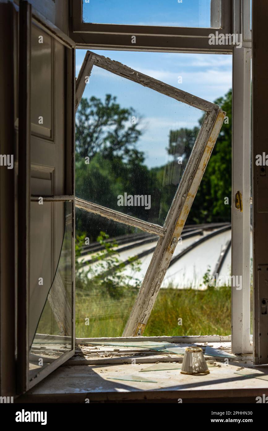 Fenêtre tombant de son cadre dans un hôtel abandonné. Banque D'Images