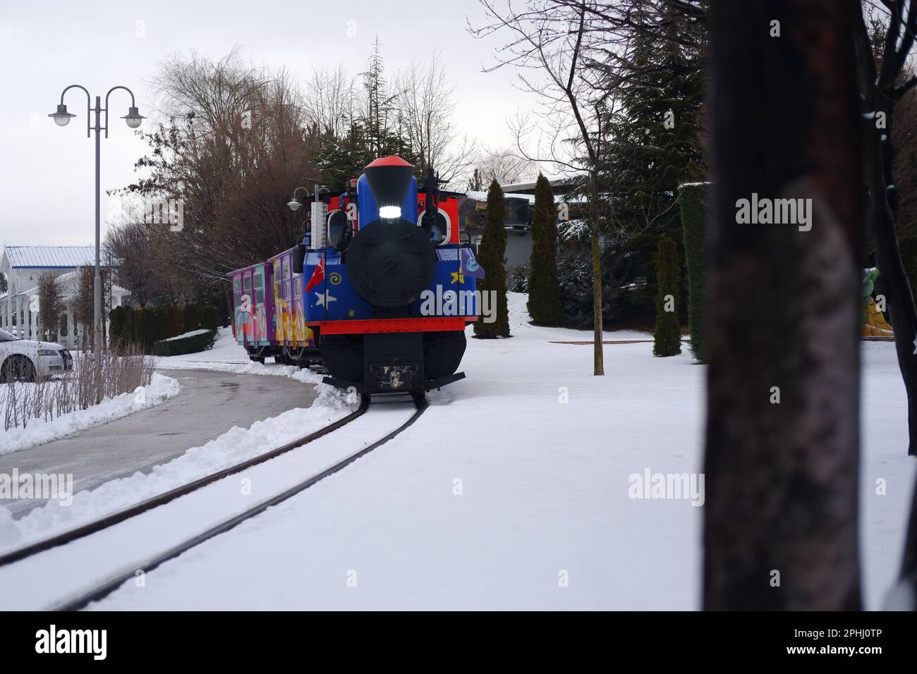 Train coloré pour s'approcher dans les arbres sous la neige en hiver Banque D'Images
