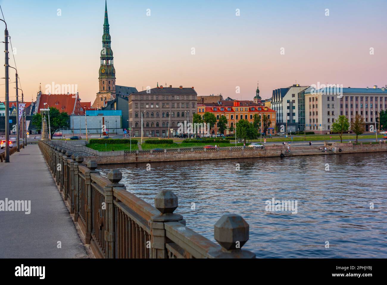 Coucher de soleil dans la vieille ville de riga, y compris l'église saint peters vue sur la rivière daugava, Lettonie. Banque D'Images