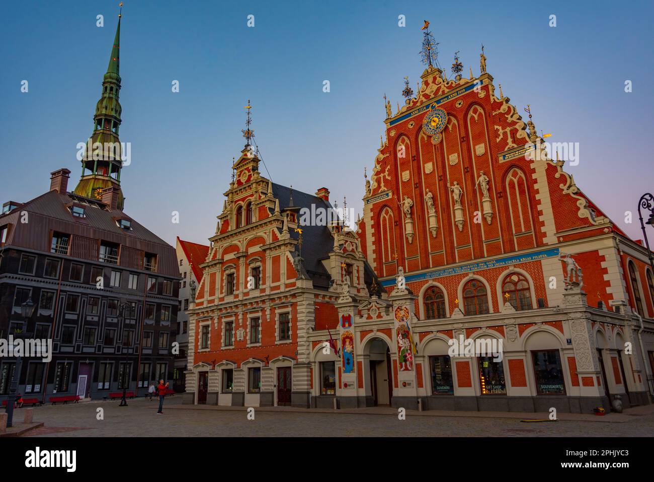 Coucher de soleil sur la place Ratslaukums avec église Saint-Pierre et Maison des Blackheads dans la vieille ville de Riga en Lettonie. Banque D'Images