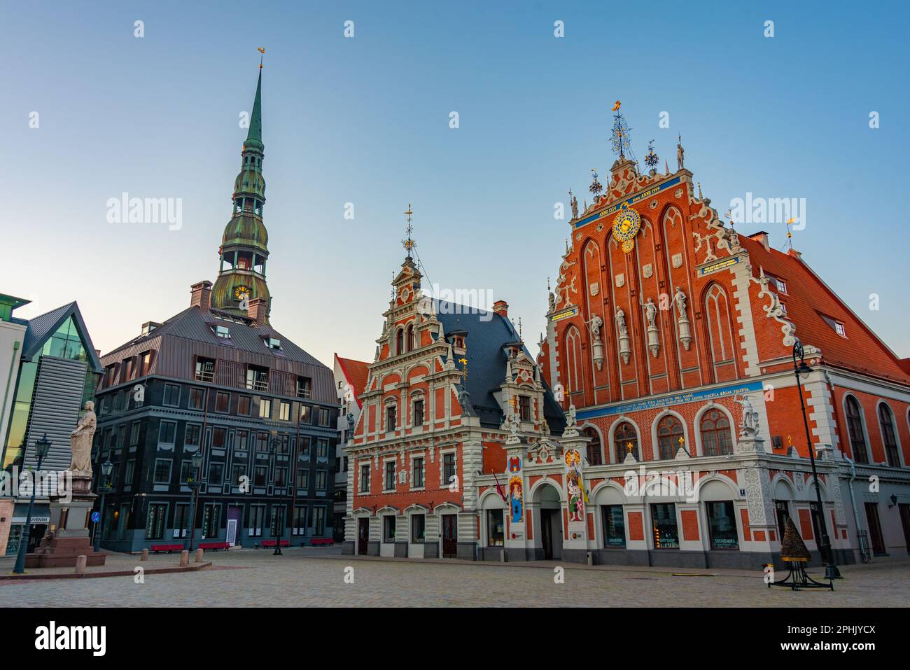 Lever du soleil sur la place Ratslaukums avec l'église Saint-Pierre et la Maison des Blackheads dans la vieille ville de Riga en Lettonie. Banque D'Images