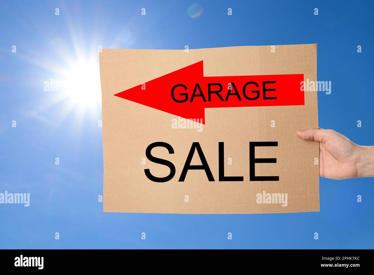 Femme tenant signe avec texte VENTE DE GARAGE contre ciel bleu Banque D'Images