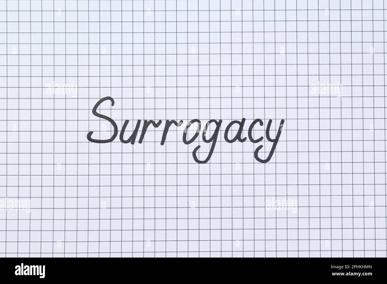 Word Surrogacy écrit sur du papier à carreaux, vue du dessus Banque D'Images