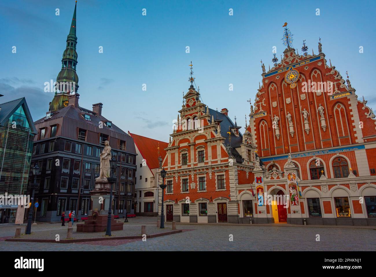 Coucher de soleil sur la place Ratslaukums avec église Saint-Pierre et Maison des Blackheads dans la vieille ville de Riga en Lettonie. Banque D'Images