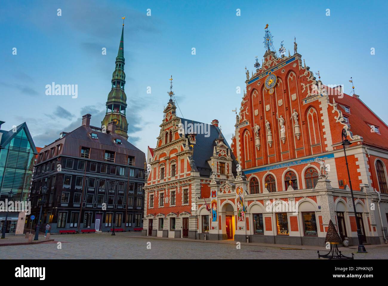 Coucher de soleil sur la place Ratslaukums avec église Saint-Pierre et Maison des Blackheads dans la vieille ville de Riga en Lettonie. Banque D'Images