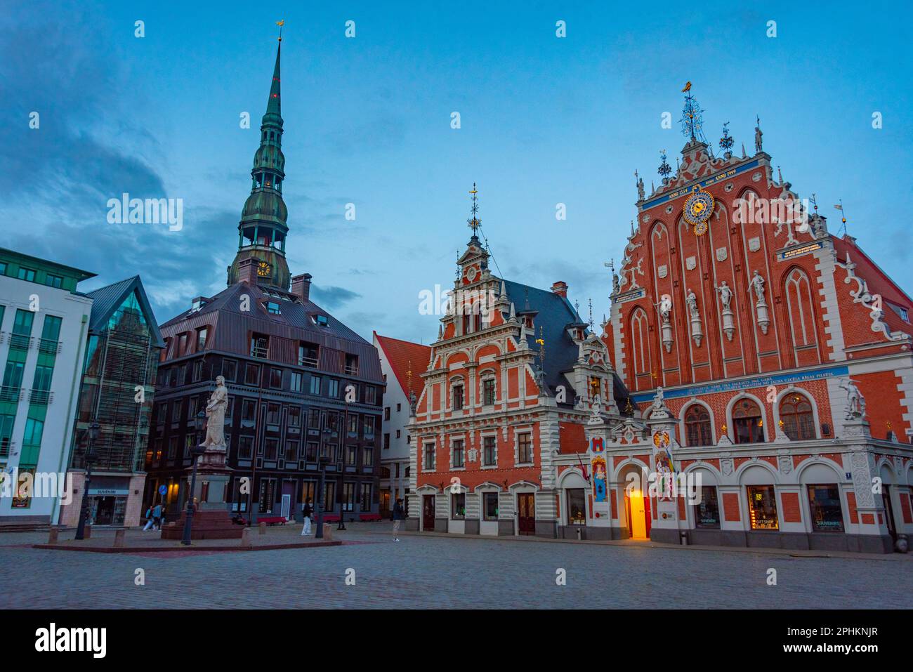 Coucher de soleil sur la place Ratslaukums avec église Saint-Pierre et Maison des Blackheads dans la vieille ville de Riga en Lettonie. Banque D'Images