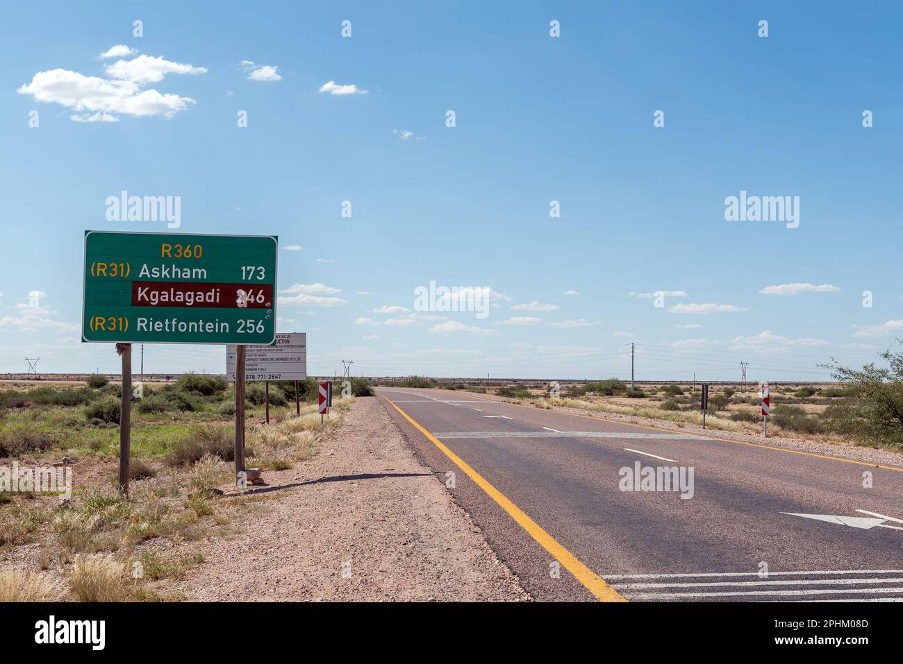 Upington, Afrique du Sud - 24 février 2023 : une scène routière au nord d'Upington, avec un signe de distance, sur la route R360 jusqu'au parc transfrontalier de Kgalagadi dans le N Banque D'Images