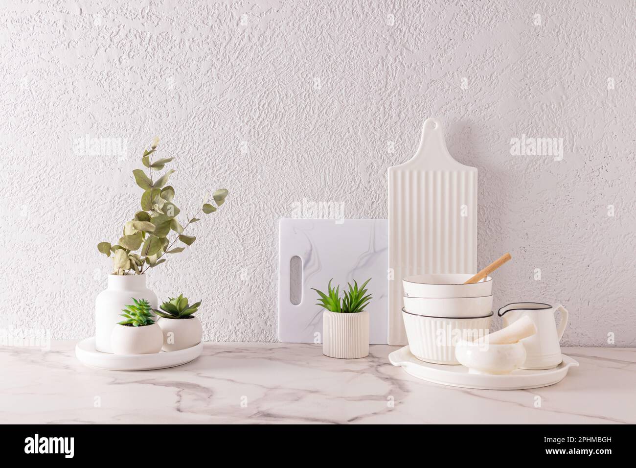 Magnifique blanc dans un style minimaliste cuisine fond avec des ustensiles blancs et des fleurs d'intérieur dans des pots en céramique. Look élégant sur le devant. un espace de copie Banque D'Images