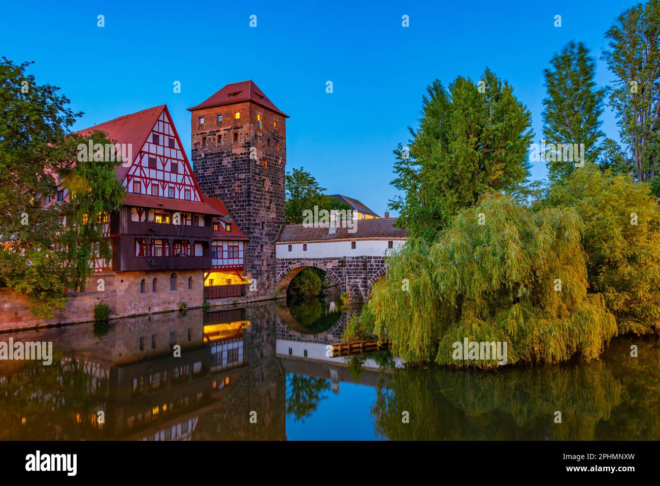 Vue au coucher du soleil sur le bâtiment Weinstadel, le château d'eau, le pont Hencurbrücke et la tour Henkerturm à Nuremberg, en Allemagne. Banque D'Images