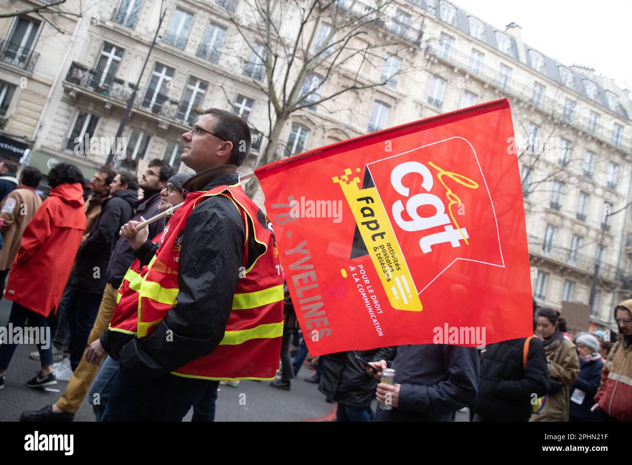 PARIS, France. 28th mars 2023. Un protestataires détient un drapeau syndical de la CGT lors d'une manifestation à Paris au sujet de la réforme des retraites. Le président Macron veut présenter un projet de loi qui fera passer l'âge de la retraite de 62 à 64 ans. Crédit : Lucy North/Alamy Live News Banque D'Images