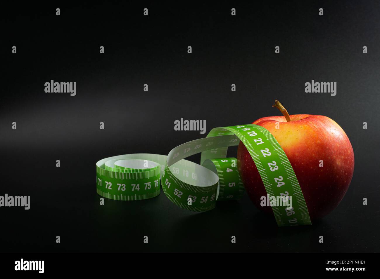 Red Apple et Measuring Tape, Measure Tape, Metric Tape on Black Background, Health Diet Food, concept de perte de poids Banque D'Images