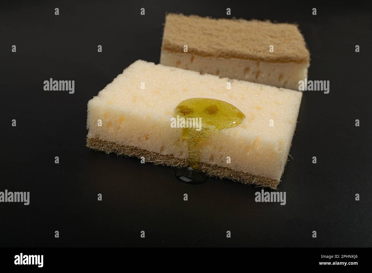 Éponge à savon naturel avec goutte de détergent, savon liquide sur éponges Eco Brown sur fond noir, espace de copie Banque D'Images