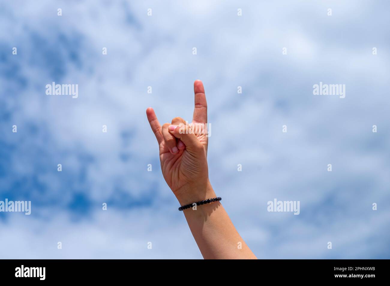 main d'une fille faisant le signe des cornes avec ses doigts Banque D'Images