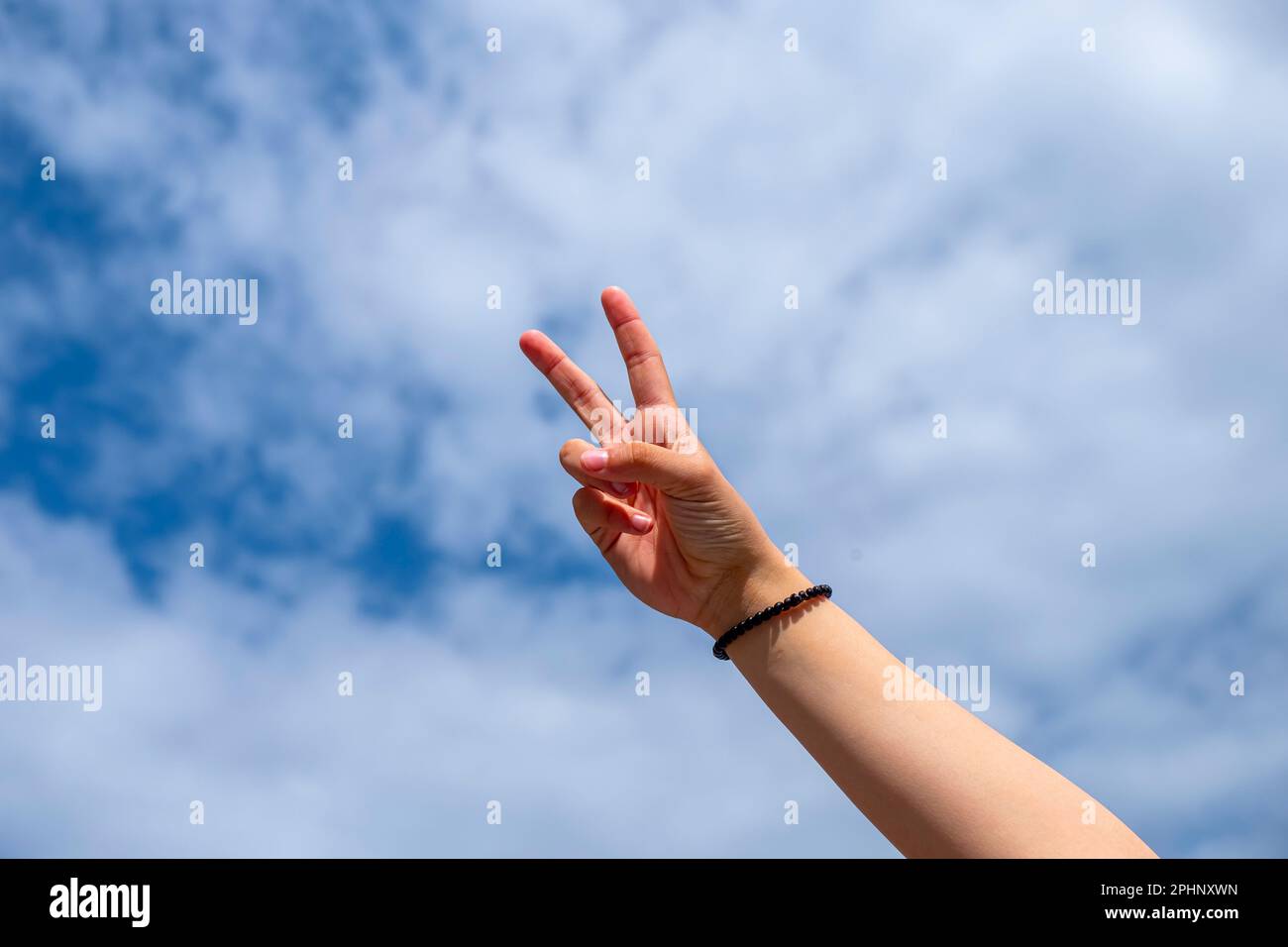 la main d'une fille faisant un signe de victoire avec ses doigts Banque D'Images