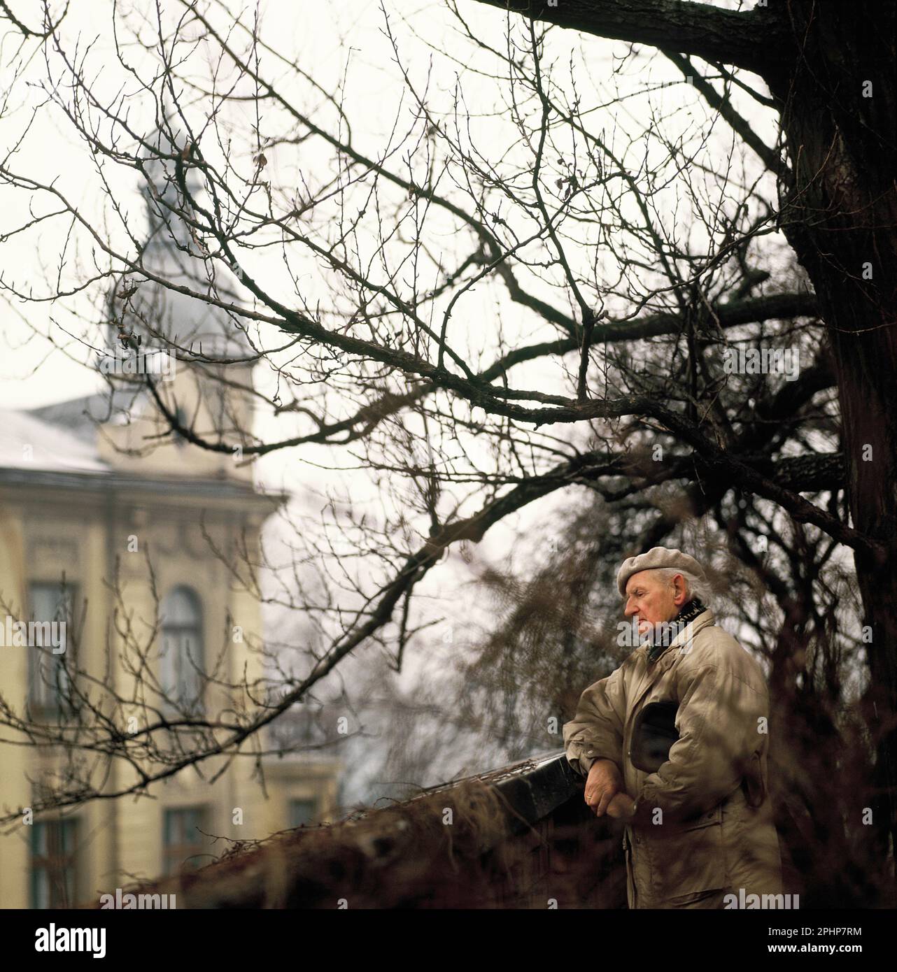 Pologne. Province de la Pologne inférieure. Vieil homme à l'extérieur surplombant le bâtiment historique. Banque D'Images