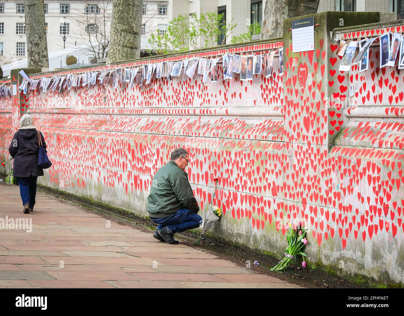 Londres, Royaume-Uni. 29th mars 2023. Un homme réfléchit tranquillement. Des familles, des amis, des collègues et d'autres personnes endeuillées se souvenant des victimes du coronavirus sont venus célébrer aujourd'hui l'anniversaire du mur national du Covid, organisé par les amis du mur, le long de la Tamise. Des photos de centaines de victimes sont affichées sur une longue ligne le long du mur.le mur a été créé pour la première fois en 2021 et son anniversaire est le mercredi 29th mars. Credit: Imagetraceur/Alamy Live News Banque D'Images
