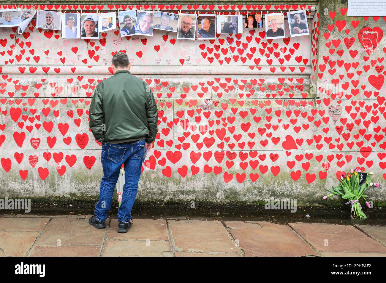 Londres, Royaume-Uni. 29th mars 2023. Un homme réfléchit tranquillement. Des familles, des amis, des collègues et d'autres personnes endeuillées se souvenant des victimes du coronavirus sont venus célébrer aujourd'hui l'anniversaire du mur national du Covid, organisé par les amis du mur, le long de la Tamise. Des photos de centaines de victimes sont affichées sur une longue ligne le long du mur.le mur a été créé pour la première fois en 2021 et son anniversaire est le mercredi 29th mars. Credit: Imagetraceur/Alamy Live News Banque D'Images