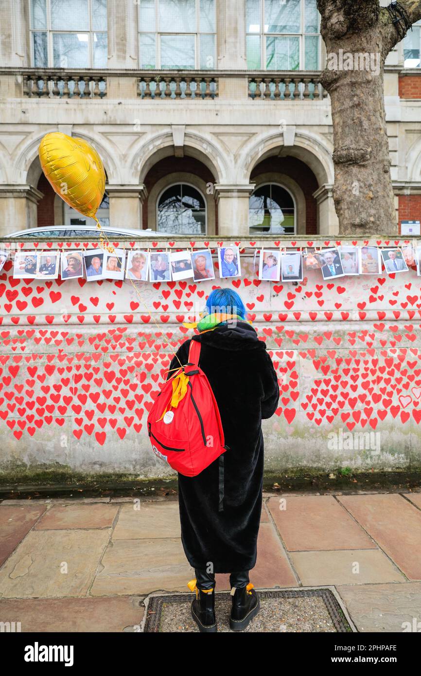 Londres, Royaume-Uni. 29th mars 2023. Une femme se tient tranquillement, regardant les images. Des familles, des amis, des collègues et d'autres personnes endeuillées se souvenant des victimes du coronavirus sont venus célébrer aujourd'hui l'anniversaire du mur national du Covid, organisé par les amis du mur, le long de la Tamise. Des photos de centaines de victimes sont affichées sur une longue ligne le long du mur.le mur a été créé pour la première fois en 2021 et son anniversaire est le mercredi 29th mars. Credit: Imagetraceur/Alamy Live News Banque D'Images