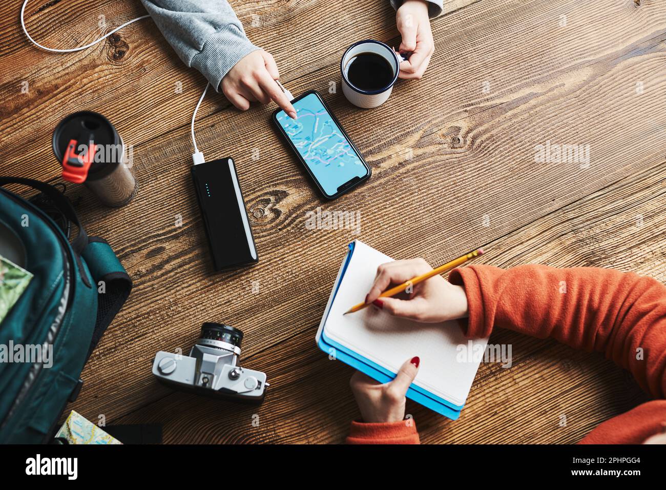 Vacances en famille. Jeune fille recherchant une destination et des itinéraires de voyage à l'aide d'une carte de navigation sur un téléphone portable. Femme écrivant journal et ne faisant pas Banque D'Images