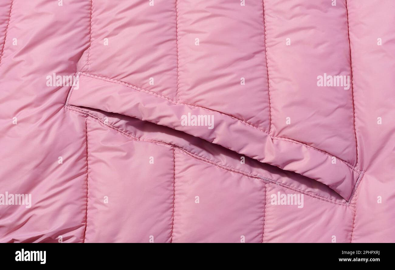 Un fragment de tissu rose avec garnissage et couture en duvet, tissu pour vestes et manteaux Banque D'Images