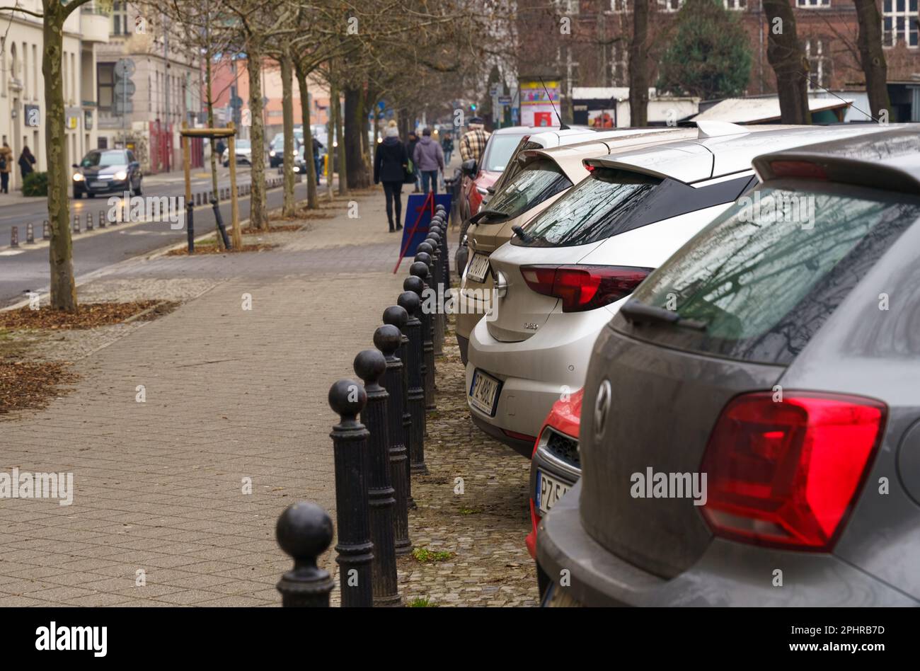 Poznan, Pologne - 20 janvier 2023: Voitures garées le long de la rue, les gens marchent le long du trottoir. Banque D'Images