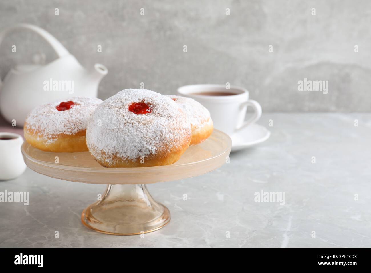 Présentoir à pâtisseries avec délicieux beignets en gelée sur table grise. Espace pour le texte Banque D'Images