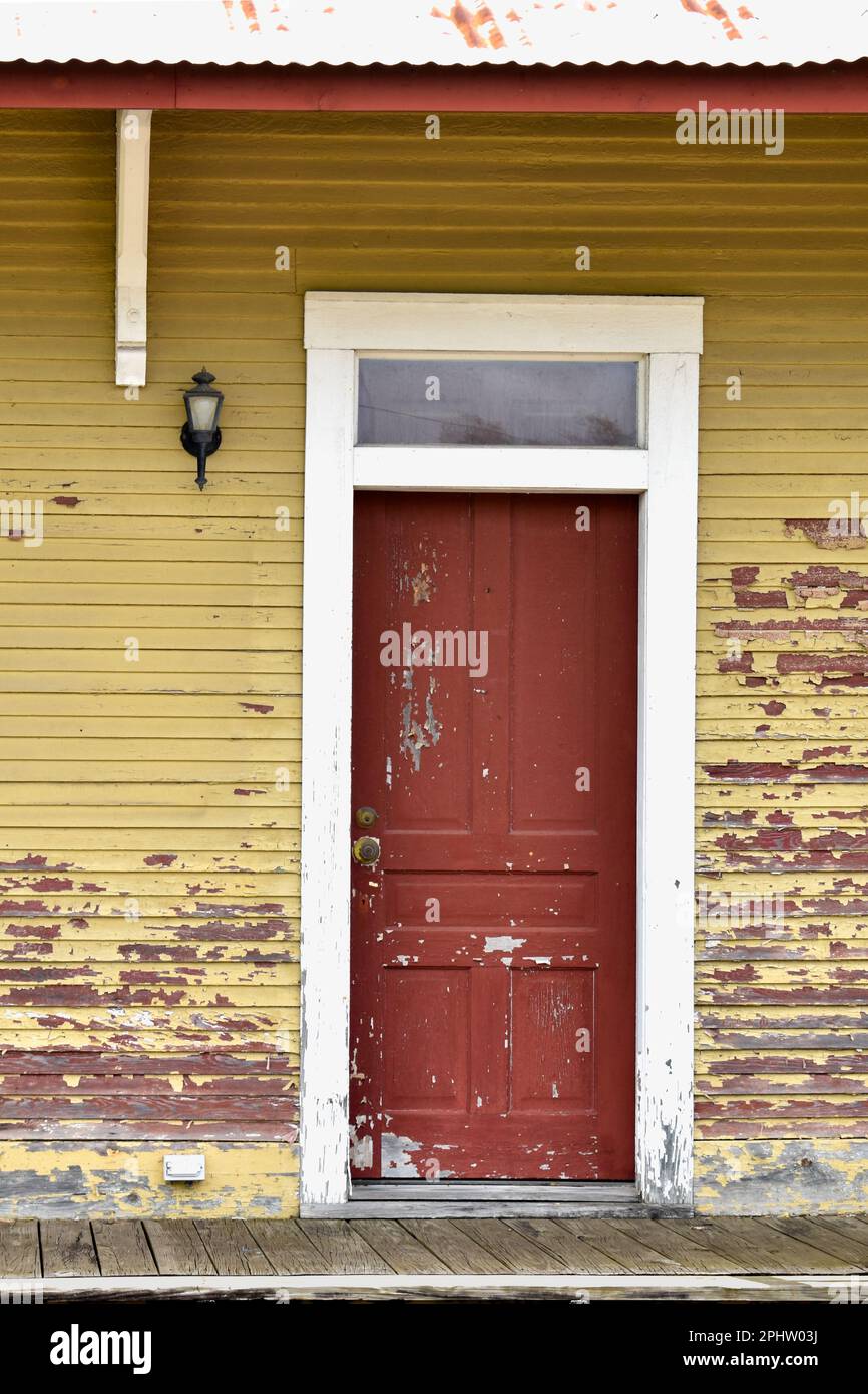 Porte d'entrée rouge et porche de l'ancienne maison jaune Banque D'Images